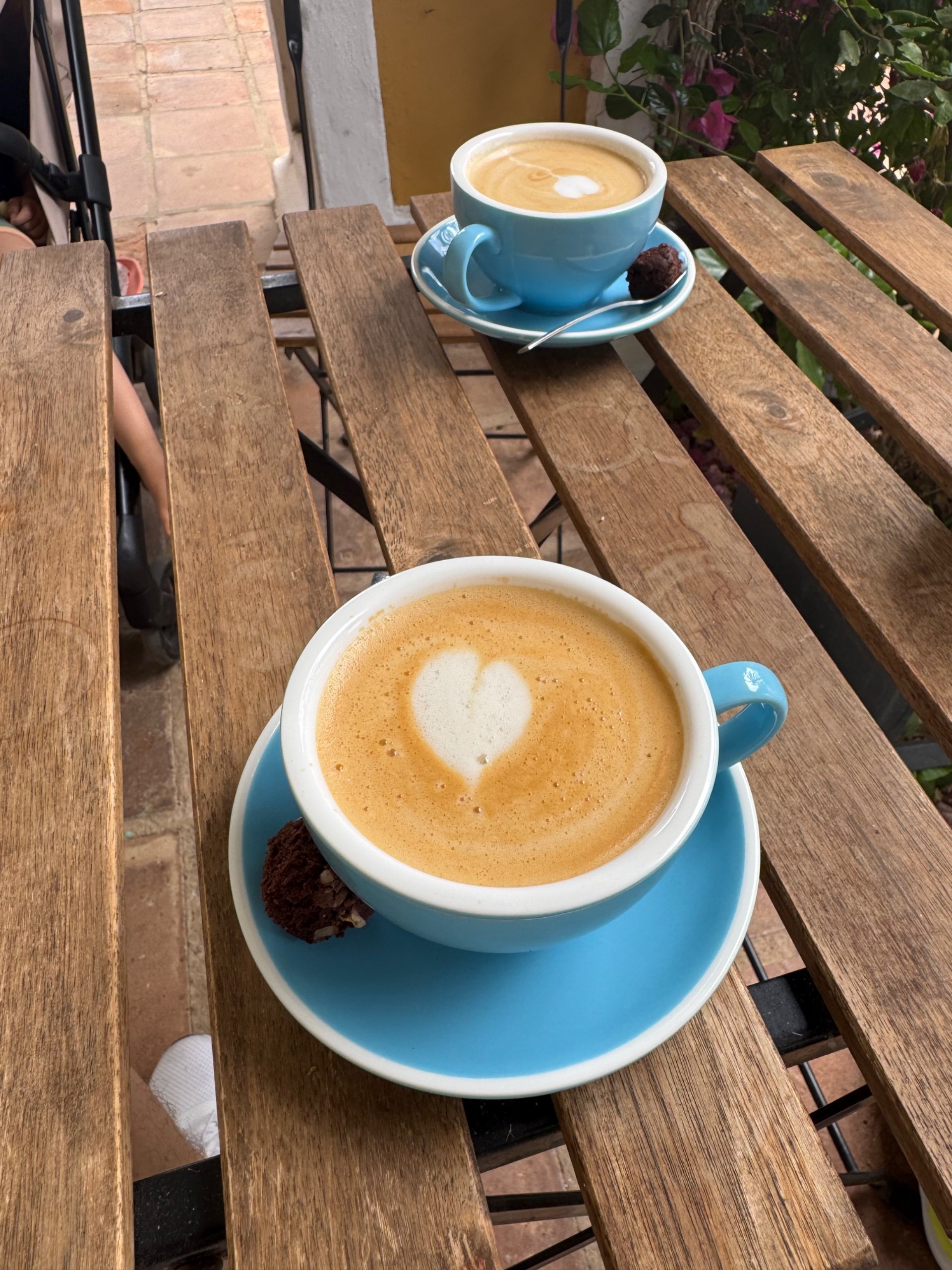 Dos lattes con corazón en el patio entre palmeras